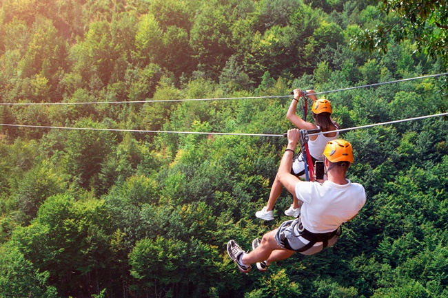 Ein Paar beim Ziplining im Wald