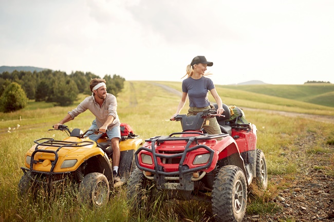 Ein Paar auf Quads auf einer Wiese